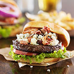 gourmet burgers on wooden table with bleu cheese and bacon