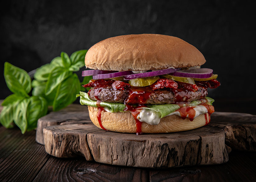 Delicious juicy burger from Brioche Bun, Steak New York, American Cheddar, Sun-dried tomatoes, Red onion, Onion marmalade, Iceberg. Hamburger for poster or menu.