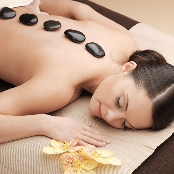 woman receiving hot stone massage therapy at a luxury resort