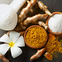 Thai Spa Set for body massage and skin care consists of sea salt, ground turmeric. on rustic black background top view with copyspace.